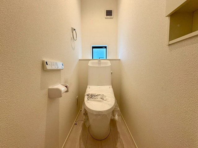 「広々インナーバルコニー」高知市東城山町2号棟　新築一戸建てのトイレ|洗い一体型の温水洗浄便座を採用。換気や採光に便利な小窓、収納棚も備えています。