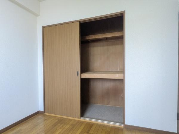 マンション猪野ハイツの収納|木目調の扉がシンプルで落ち着いた印象の収納です。奥行きがあり上下に分かれた棚も便利に使えます。スライド扉なのでスペースを有効活用できます。お部屋の一角にすっきりと設置されています。