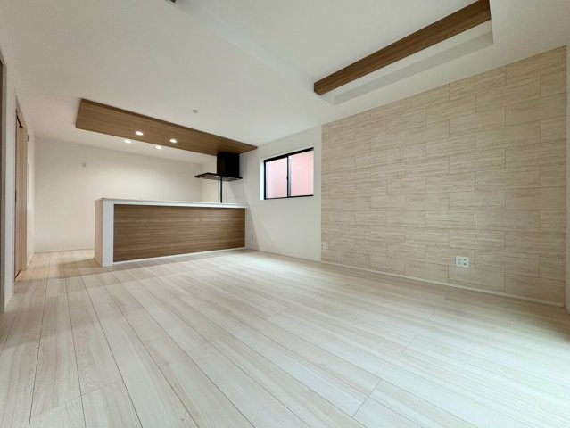 「独立洗面設計」高知市東城山町1号棟　新築一戸建ての居間・リビング|エコカラット風の壁面がお部屋を格上げ。温かみのあるモダンな空間です。
