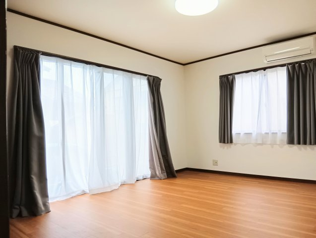 売中古戸建　静岡市葵区建穂１丁目の居間・リビング|白い壁とナチュラルな木目フローリングが調和した明るいLDK。大きな掃き出し窓と腰窓による2面採光。