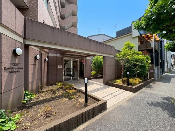クリオ大師公園南壱番館のエントランス|エントランスは広々としたアプローチが印象的です。緑が配置されており明るい雰囲気が感じられます。歩道との段差も少なくスムーズに出入りできます。外壁には照明も備わり夜間でも安心です。