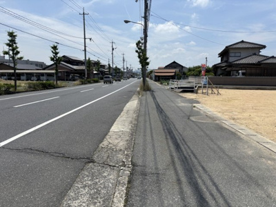【前面道路含む現地写真】 | 土地　金光町占見新田　全1区画　102.13坪 | 前面道路は幅員約19ｍの県道です。