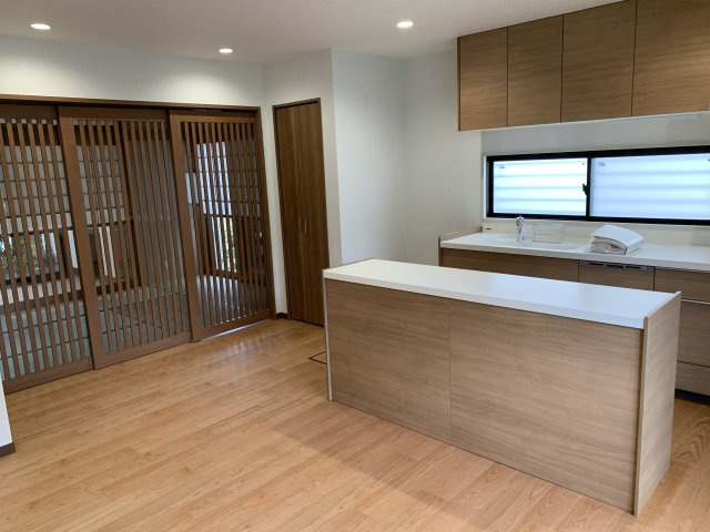 西明石　鳥羽一戸建て　の居間・リビング|間仕切りはパナソニック製３連格子型スライド建具で仕切りました。洋室、和室まで見渡せ開放感あります。