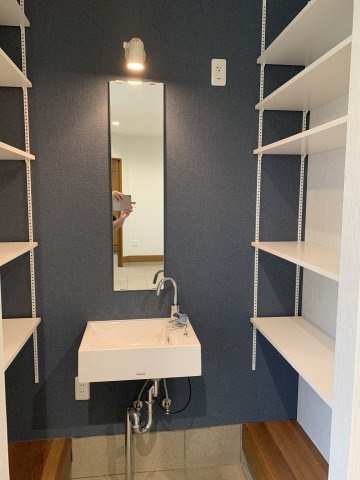 西明石　鳥羽一戸建て　の洋室|1階洋室にある鏡付きの手洗い場です。両サイドに棚があり収納豊富です。