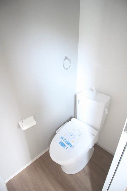 小山市東城南２丁目の新築一戸建のトイレ|玄関やLDKから利用しやすい1階トイレ。温水洗浄便座付きで、白い壁と木目調の床を組み合わせた清潔感のある空間です。