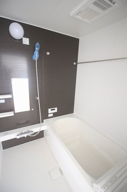 小山市東城南２丁目の新築一戸建の浴室|落ち着いた色合いのアクセントパネルを採用した浴室。浴室暖房乾燥機付きで、雨の日の洗濯物干しや寒い季節の入浴準備に役立ちます。