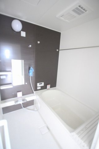 小山市東城南２丁目の新築一戸建の浴室|落ち着いた色合いのアクセントパネルを採用した浴室。浴室暖房乾燥機付きで、雨の日の洗濯物干しや寒い季節の入浴準備にも役立ちます。