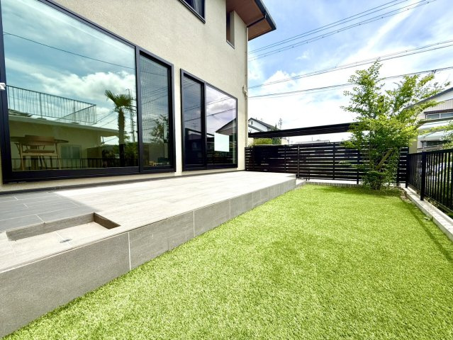 緑区ほら貝三丁目戸建の庭|タイルデッキと人工芝が広がる、開放感あふれるプライベートガーデン