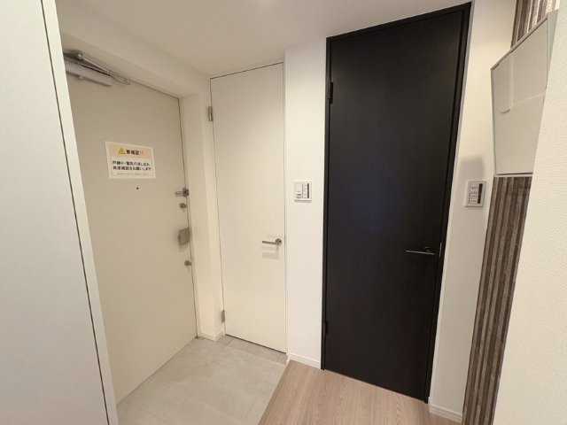 プレシス府中リヴェスタの玄関|白を基調とした空間にダークカラーの建具がアクセントの玄関です。