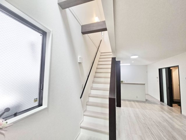 中古戸建　大阪市西淀川区中島1丁目の居間・リビング|リビングを開放的に見せるアクセント階段。いつでも家族の気配を感じられる子育て世代に嬉しいリビング階段。