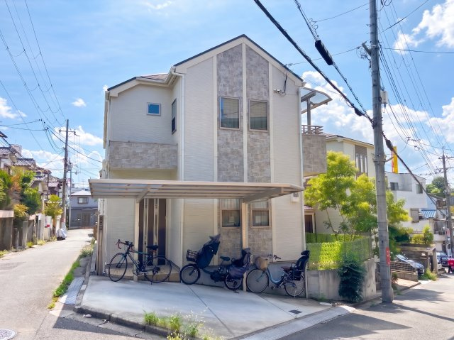 【中古戸建て/庭付き】枚方市松丘町2階建ての外観|外観：二面道路に面する物件。淡いベージュカラーの外壁に、上品なアクセントを用いたおしゃれな外観デザイン