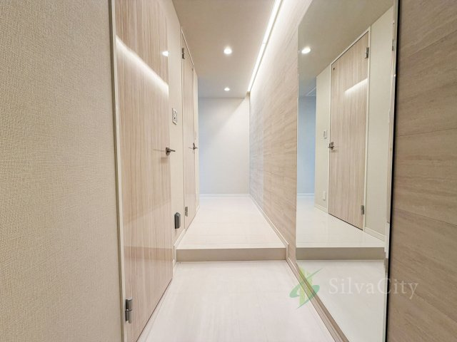 カテリーナ三田タワースイートの玄関|明るく開放的な空間を木目が美しい建具が見事に演出。住まいの顔となる玄関は、落ち着きと華やぎの満ちた空間に。ご家族の「行ってきます」「ただいま」を見守り続けます。