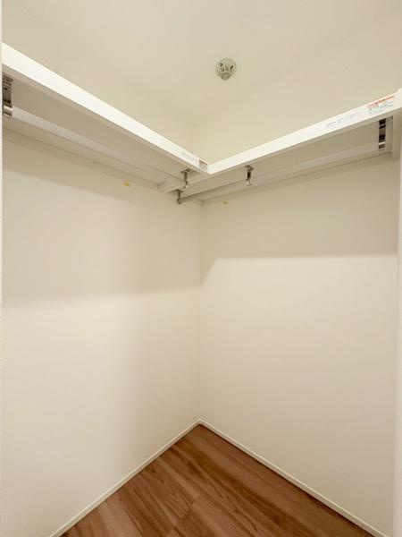 カサベルダの収納|6.1帖の洋室のウォークインクローゼットです。シンプルな内装で使いやすい収納スペースです。清潔感のある明るい印象が特徴です。ハンガーパイプ付きで衣類の整理がしやすいです。