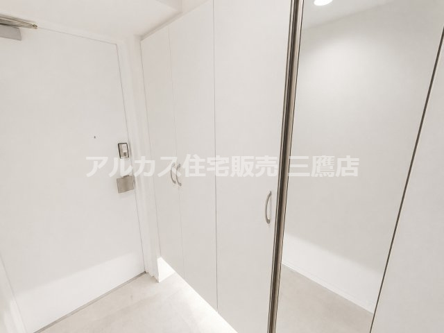 【内覧動画公開中！】ルネファンタグラーレ府中是政の玄関|鏡付きのシューズ収納を備えた、白を基調とした清潔感のある玄関空間。