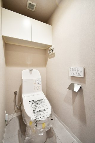 パークシティ大宮セントラルタワーB棟のトイレ|【リフォーム済】温水洗浄便座一体型便器。シンプルで衛生的な洗浄便座です◎清潔感のあるトイレ吊戸棚がついておりますので備品補充も楽々行えます。扉付きで生活感を隠せる為、掃除用具をしまうのもおすすめです。
