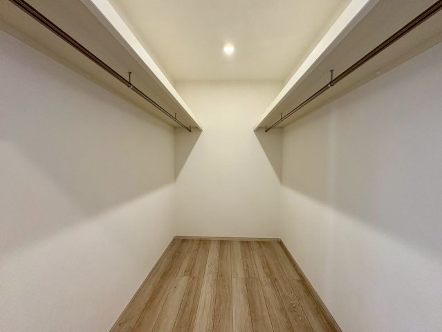 「長期優良住宅」香南市野市町西野　新築戸建　西棟の収納|両側にハンガーパイプを備えた大容量ウォークインクローゼット。衣類や季節物をすっきり一括管理できます。