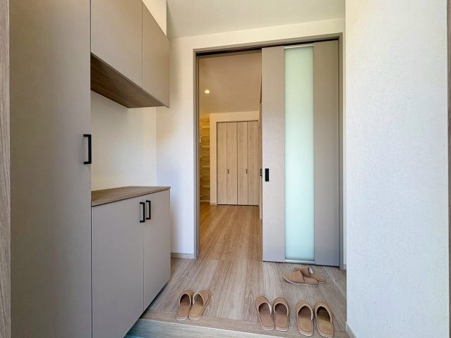 「長期優良住宅」香南市野市町西野　新築戸建　西棟の玄関|コの字型の大型シューズボックスを備えた玄関。スリットガラス入りのハイドアから、明るい光が差し込みます。