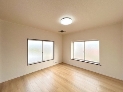 【洋室】 | 弘前市大字栄町3丁目・中古住宅 | 2階東側8帖洋室です。床はフローリング重ね張り、壁・天井のクロスは貼り替えを行いました。照明はLEDの新品に交換しました。