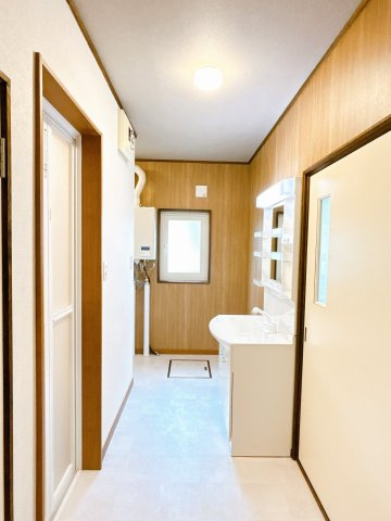 北見市東陵町１３２番地２８　平家建中古売家の脱衣所|【リフォーム済】脱衣所写真です。こちらは廊下からとキッチン台所からと入り口が2か所ありますので使用勝手が良い動線になっております。フロア貼替、壁、天井のクロス貼替を行いました。