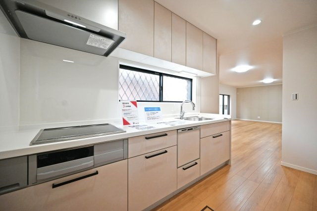 宝塚市中州1丁目中古戸建｜3LDK＋駐車1台可のキッチン|窓のあるキッチンは、手元に自然光を取り込みやすい明るい空間。IHクッキングヒーターや食洗機を備え、吊戸棚も設けるなど、毎日の使いやすさと収納力にもこだわっています。