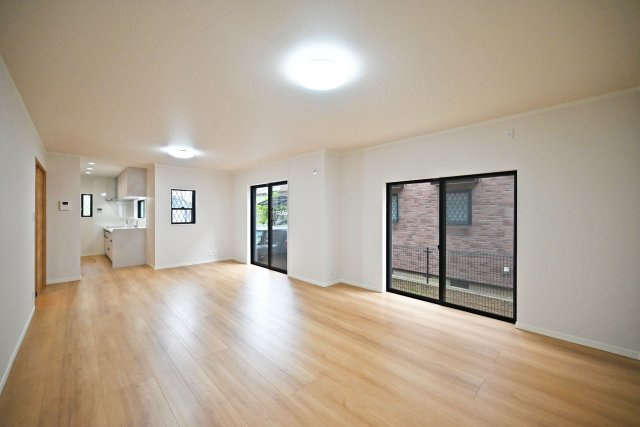 宝塚市中州1丁目中古戸建｜3LDK＋駐車1台可の居間・リビング|キッチンまで視線がつながるゆとりある空間。複数の窓から光を取り込み、ナチュラルな木目の床がやさしく明るい雰囲気を演出します。