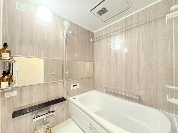 クレストフォルム市が尾南の浴室|浴室は清潔感のあるデザインで明るい空間が広がっています。大きな鏡が設置されており開放感を感じられます。収納スペースや棚もあり使い勝手の良さを感じられます。壁面は上品な色合いでまとめられています。