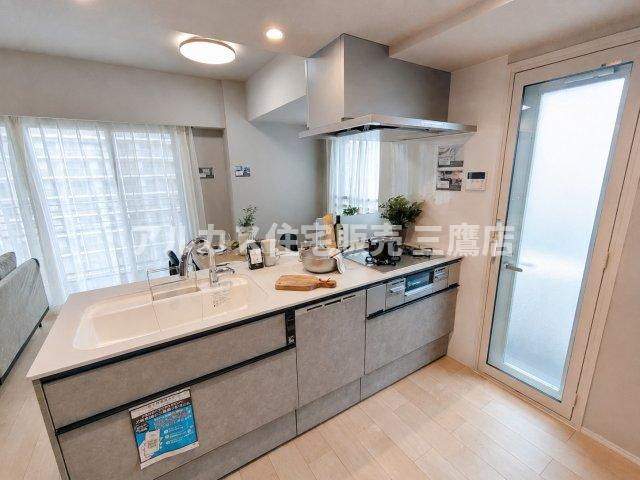 デュオ府中駅前のキッチン|モルタル調の質感がおしゃれな、バルコニーへ直接出入りできる勝手口付きの対面キッチン。