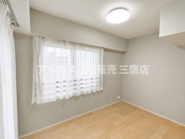デュオ府中駅前の洋室|グレージュの壁と木の温もりが心地よい、大きな窓から光が注ぐ明るい洋室。