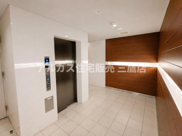 デュオ府中駅前のその他共用部分|木目調の壁と間接照明が温かみを添える、ホテルライクで上品なエレベーターホール。