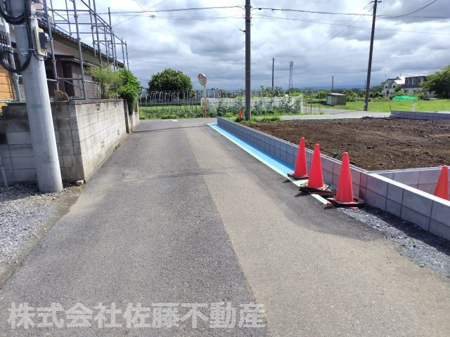 【分譲地】北鴻巣駅14分・46坪の整形角地の前面道路含む現地写真|2026年6月21日 14:30頃撮影。E区画の南東側接道の北東側から南西方向へ撮影した鴻巣市道の様子。右手にE区画が見えます。ブロック塀を新設したため、こちら側からは出入りはできません。