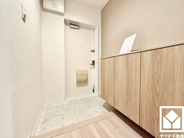 武庫川樹のまち第一第一三号棟の玄関|白を基調とした明るい玄関で、毎日を爽やかにスタート。清潔感あふれる空間が、訪れる人々を温かく迎えます。