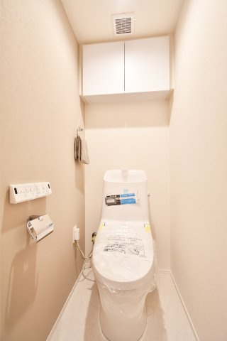 アルーサ北与野ノースピア上落合2号棟のトイレ|温水洗浄機能付きトイレ　白が基調で、快適で衛生的なトイレです！吊戸棚付きで、トイレットペーパーなどの備品補充も楽々行えます。掃除用具をしまうと清潔感も消す事ができ、イマドキなお部屋にできます。