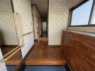 【玄関】 | 桶川市坂田西3丁目 中古戸建 ～開放感ある公道角地・カースペース2台～ | 木目調のレトロで落ち着いた雰囲気が魅力的な玄関です。手すりが設置されており、ご家族皆さまが安心してス