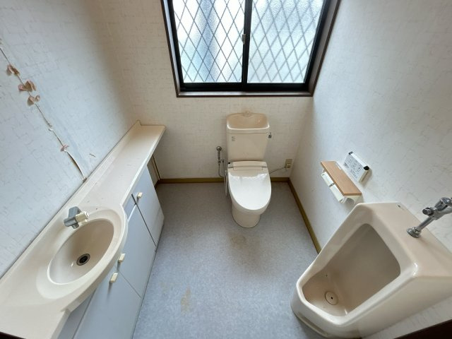 相馬市新田 4LDK＋納戸 中古平屋住宅 陽当たり良好！ 不動産プラスのトイレ|2帖サイズのトイレです。カウンター手洗いと男性用便器も備えた造りになっています。