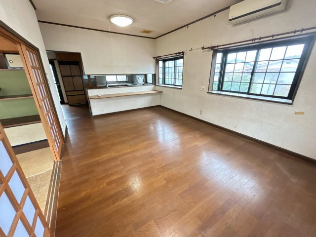 相馬市新田 4LDK＋納戸 中古平屋住宅 陽当たり良好！ 不動産プラスの居間・リビング|20帖の広めなLDKです。奥に対面キッチンが見えます。出窓もありますので明るく感じられます。