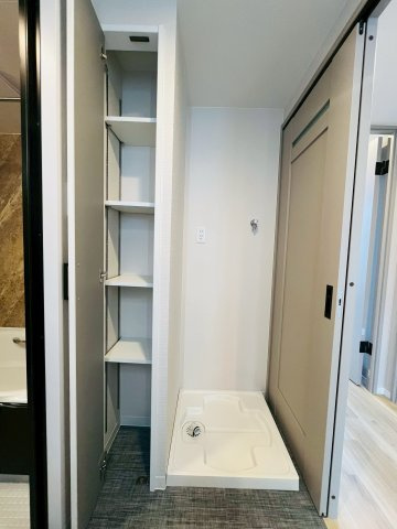 ウィズパークス大阪アクアコートの洗面所|洗濯機を置く防水パンの隣には可動棚も。取り回しやすい位置に洗剤やタオルを置いておけます。