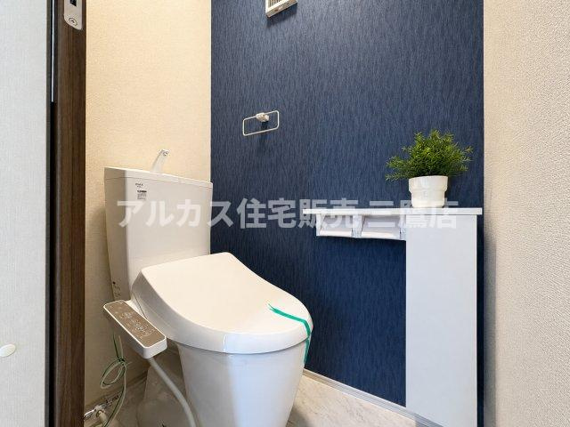 京王線 調布駅 16分 新築戸建 調布市調布ケ丘3丁目のトイレ|アクセントクロスがおしゃれな雰囲気を演出するトイレ。温水洗浄便座やペーパーホルダー下の収納カウンターを備え、機能性も良好です。