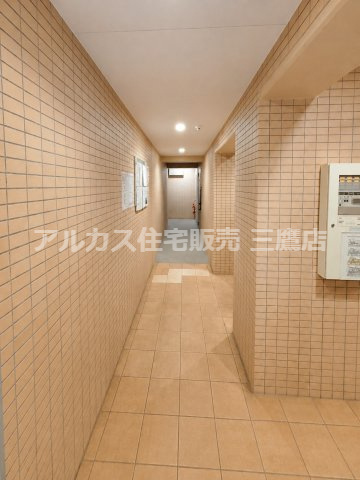 レーヴステージ府中緑町のその他共用部分|タイル貼りの壁面で統一された共用廊下。照明を備え、整った印象に仕上がっています。