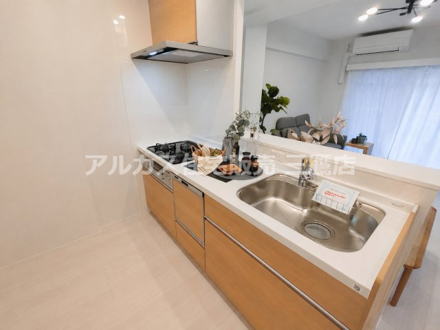レーヴステージ府中緑町のキッチン|リビング側を見渡せる対面キッチン。シンクや3口コンロ、レンジフードを備えています。