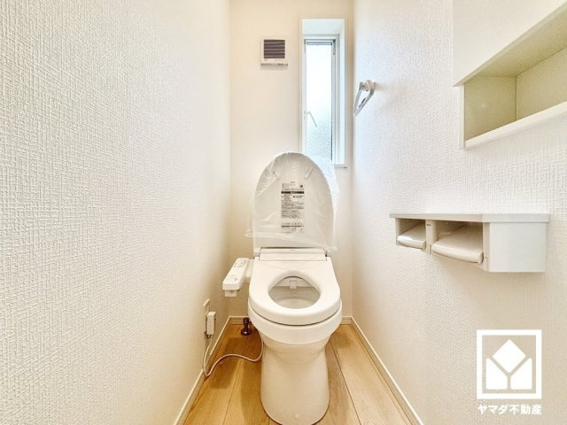 尼崎市高田町第1のトイレ|1階トイレです。間取り図と異なり、ニッチを利用した戸棚が北側に設置されています。トイレットペーパーのストックや消耗品置き場などとしてお使いいただけそうです。