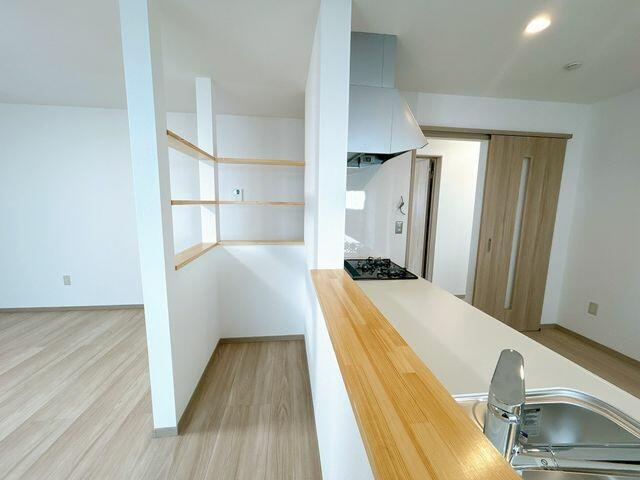 八代市古閑浜町の中古一戸建のキッチン|ＬＤＫ別角度の写真です。キッチン前には小棚を新設しています。小物を飾ってリビングを彩るk事が出来ます。