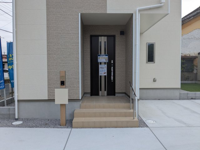 新築戸建　高崎市中豊岡町63番のその他|シックな玄関ドアと木目調のアクセントがおしゃれな玄関ポーチ。手すりや宅配ボックス付きで機能的です。