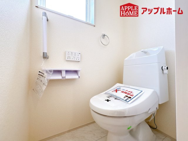 [新築住宅] 鴻巣市松原 3期 全5棟のトイレ|白を基調とした清潔感のある明るい空間。温水洗浄便座付きで、毎日快適・清潔に使用できます。操作しやすい壁面リモコンを採用しています。