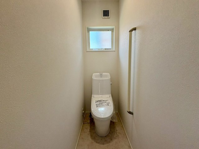 「広々4LDK」高知市瀬戸東町3丁目1号地　新築一戸建てのトイレ|白を基調とした清潔感のあるトイレ。手すりや小窓が付いており、安全性と採光・通気性にも配慮された快適な空間です。