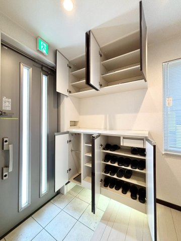 手稲本町2条5丁目　戸建の玄関|収納力豊富なシューズボックスを完備。傘専用の収納スペースも備え、玄関まわりをすっきりと保てます。ダウンライトが、優しく足元を照らします