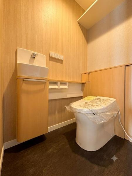 ライオンズマンション大倉山第７のトイレ|温かみのある木目調の内装が特徴的です。手洗いカウンターが設置されシンプルで清潔感があります。落ち着いた雰囲気の中で快適にご利用いただけます。設備にも工夫が施されています。