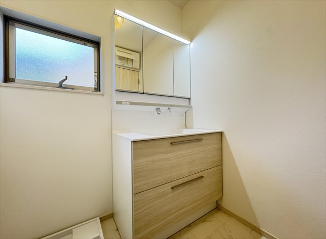 【独立洗面台】 | 志木市柏町2丁目　中古一戸建住宅　(丸井志木店) | 収納付きの三面鏡洗面化粧台を採用。洗面用品をすっきり整理できるほか、身だしなみのチェックもしやすく、忙しい朝の支度も快適です。鏡裏収納で生活感を抑えながら、すっきりとした空間を保てます。