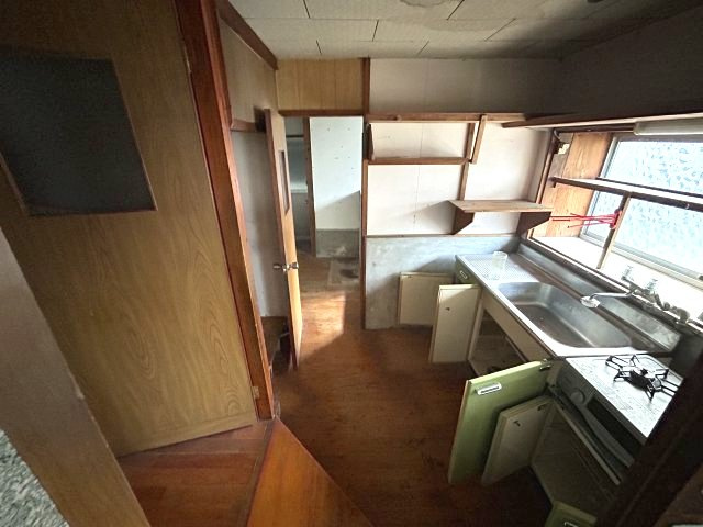 5Kに納戸と土間付｜日南市南郷町潟上・潮風香る港町に佇む戸建のキッチン|上下に収納棚を備え、正面に窓を設けた作業動線の良い台所