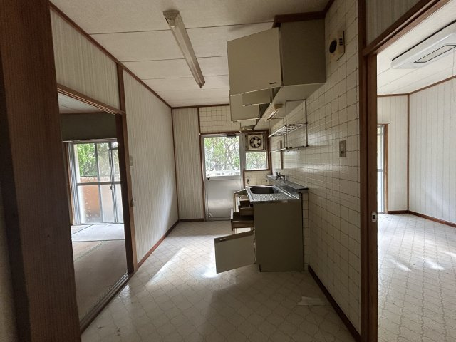 宮崎県日南市 １棟アパートの居間・リビング|タイル張りの壁。窓からの眺望も良好で、明るく風通しの良い空間です。隣接するダイニングスペースとの動線