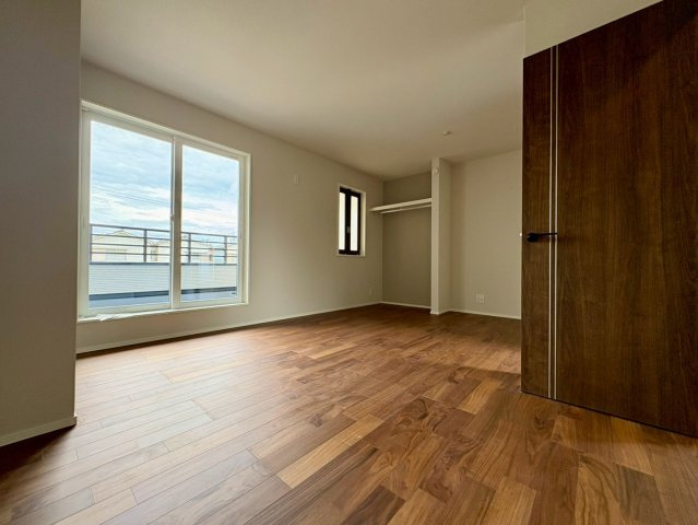 「吹き抜けのあるオシャレな美邸」高知市瀬戸東町　新築戸建の洋室|バルコニーに面した大きな窓から光が注ぐ明るい洋室。オープンクローゼット付きで、主寝室にも最適です。
